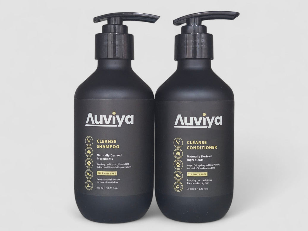 Two black Auviya shampoo and conditioner bottles on a light gray background