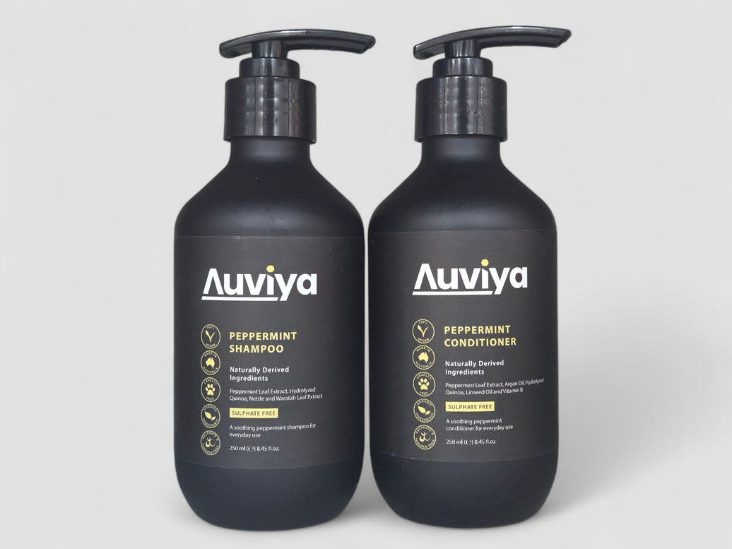 Two Auviya peppermint shampoo and conditioner bottles on a light gray background