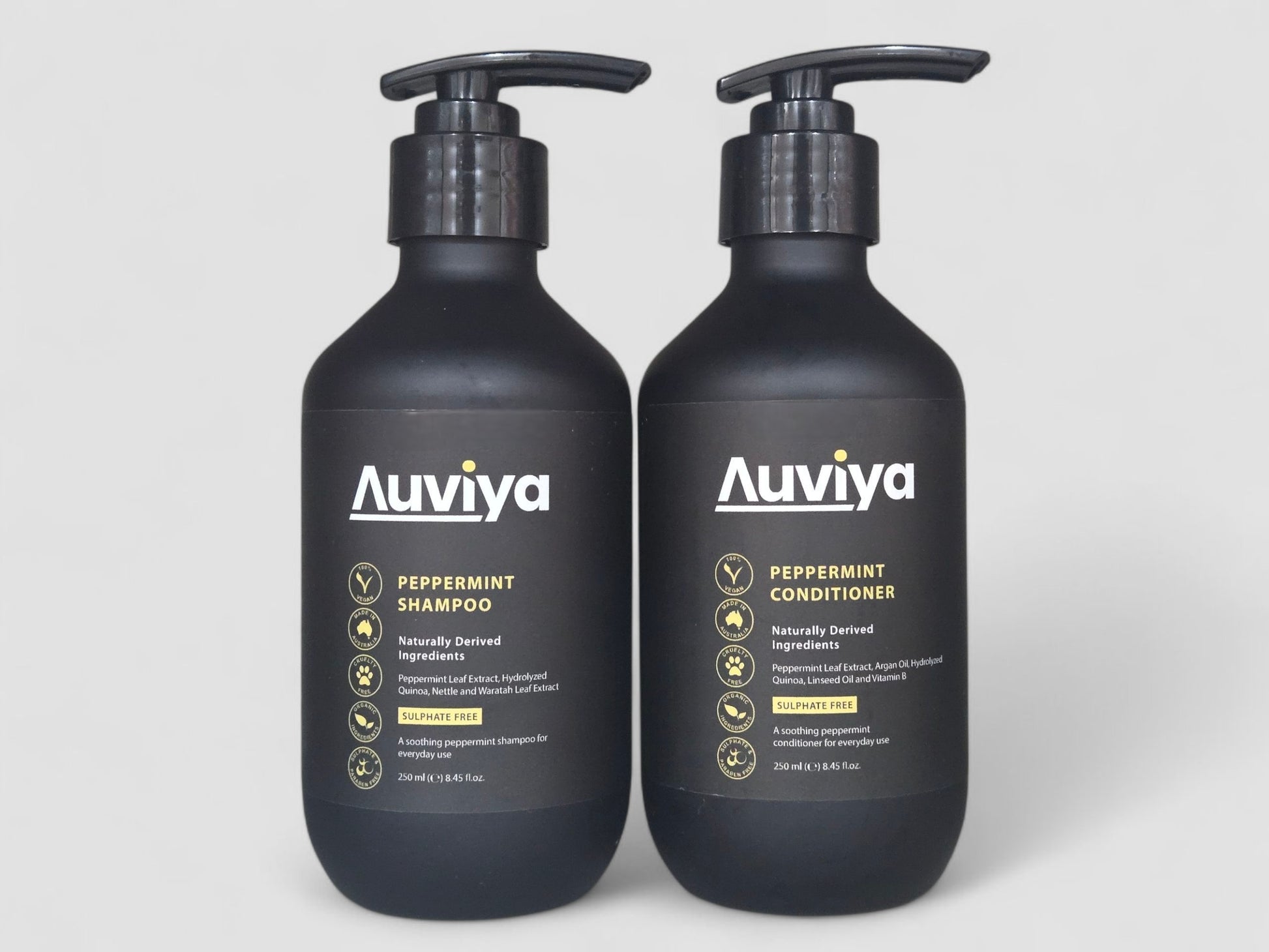 Two Auviya peppermint shampoo and conditioner bottles on a light gray background