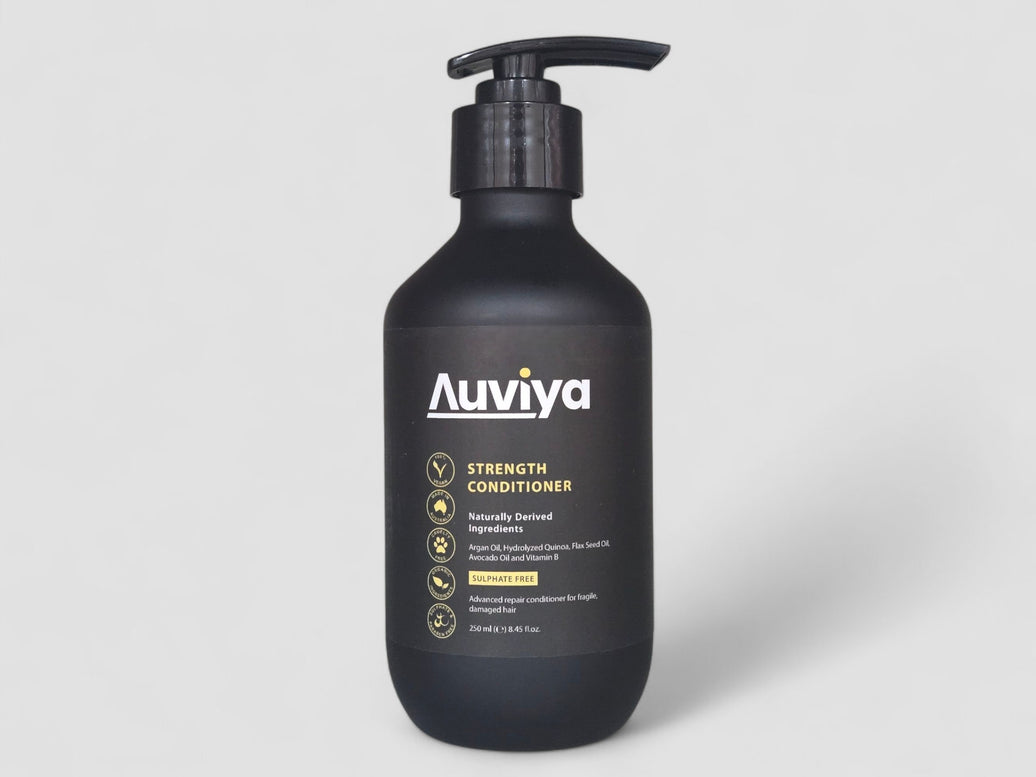 Black bottle of Auviya Strength Conditioner on a light gray background