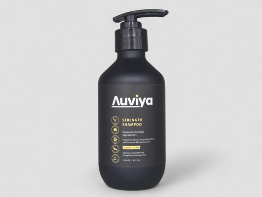 Black shampoo bottle with 'Auviya' label on a light gray background